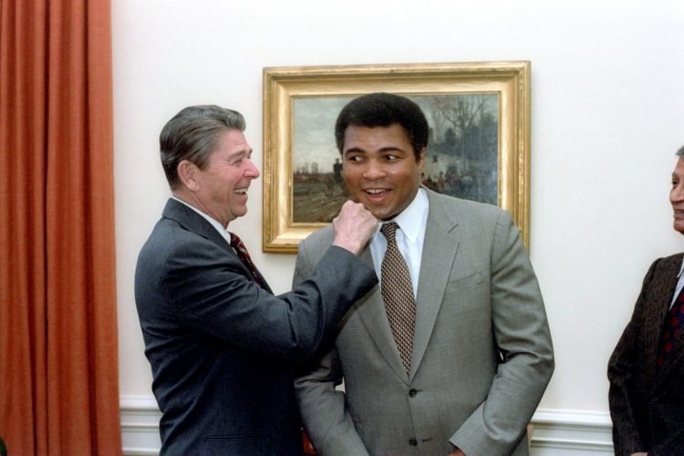 President Ronald Reagan mimics a punch to the jaw of Muhammad Ali who smiles in surprise.